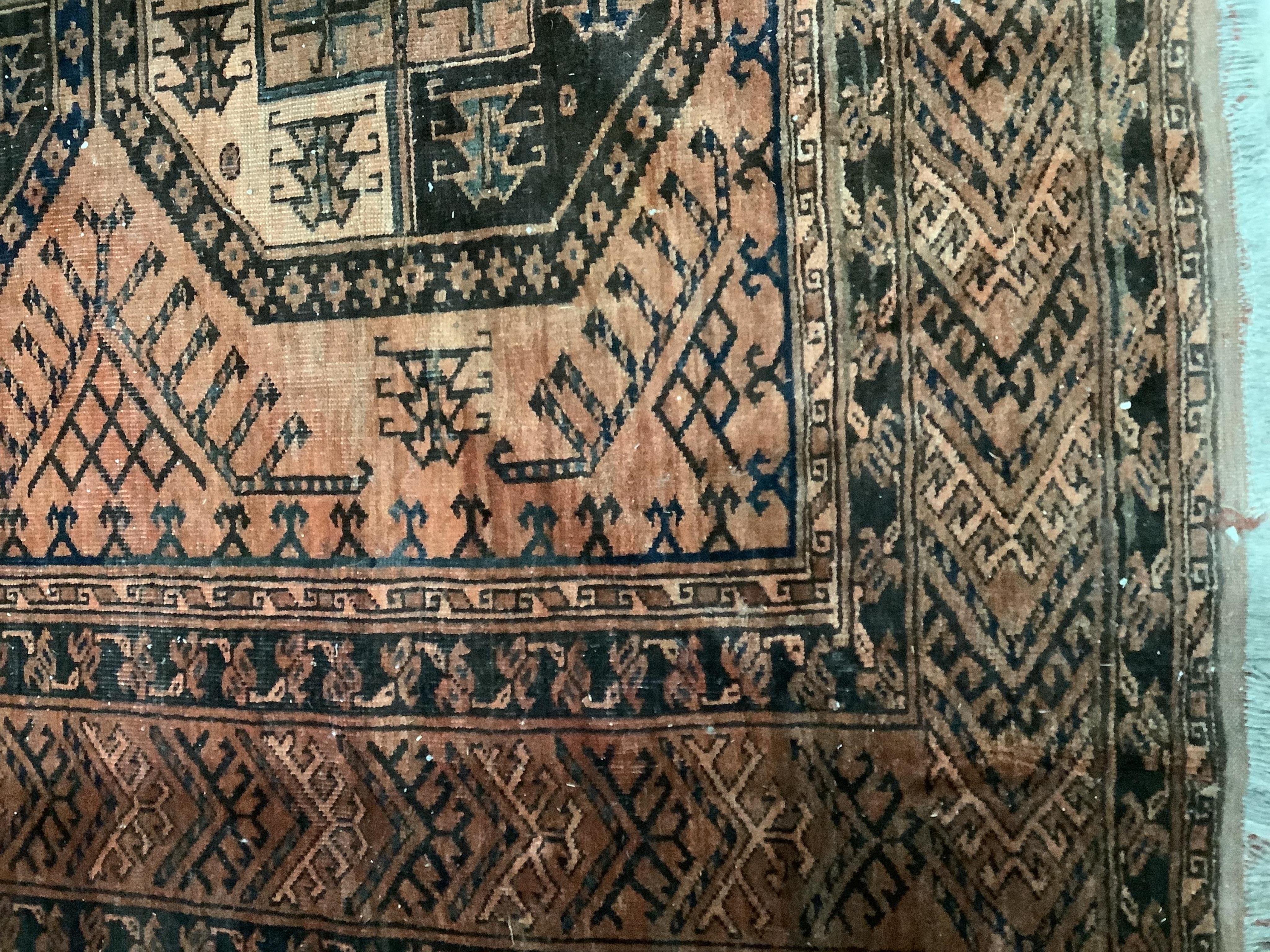 An Afghan rust ground carpet, 400 x 260cm. Condition - poor, damage to border